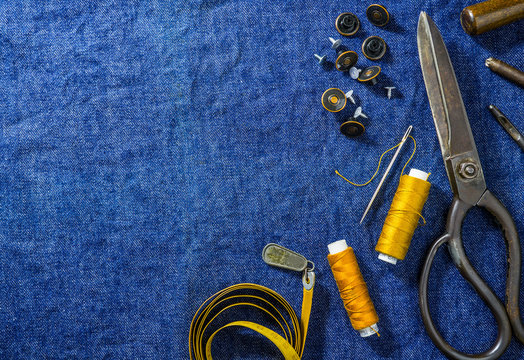 background table top view of sewing jeans on denim fabric