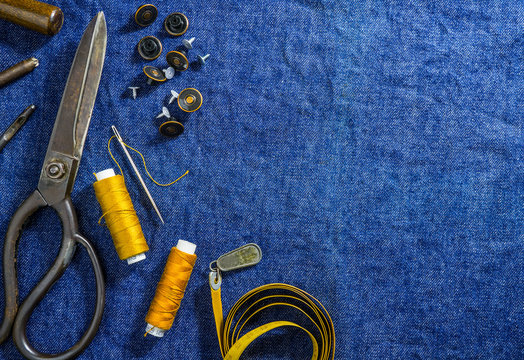 background table top view of sewing jeans on denim fabric