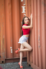 Portraits: Fashion: Asian woman, wearing a white shirt, red shorts, location: large storage...