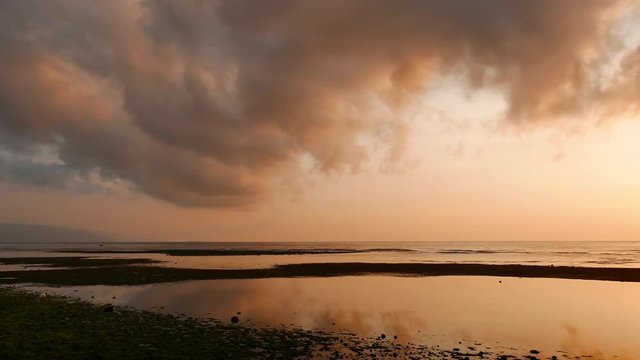 A naturally sepia tinted sunrise time lapse video from Dumaguete City. Locals can be seen gathering shellfish from the low tide pools. 