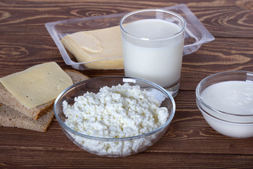 Свежий творог,молоко,сметана и сыр на деревянном фоне