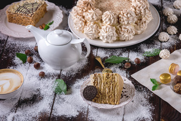 Beautifully decorated dessert table where the cake with meringue on a dark wooden table. Arrangement of delicious sweets
