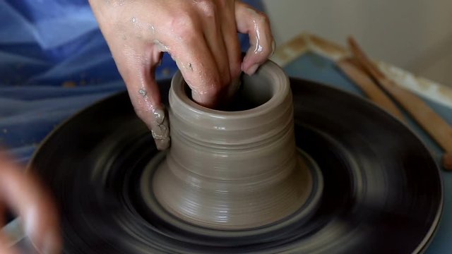 Creating jar or vase of clay. Woman hands, potter's wheel