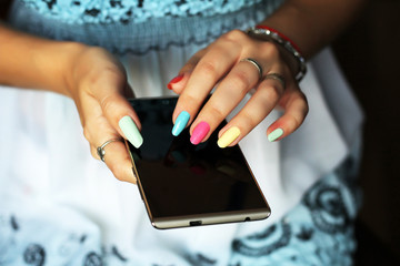 Smartphone in female hands. Beautiful manicure.