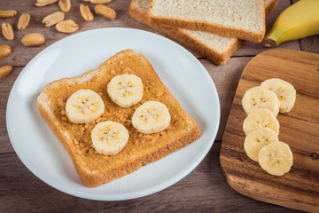 Bread with peanut butter and banana on plate