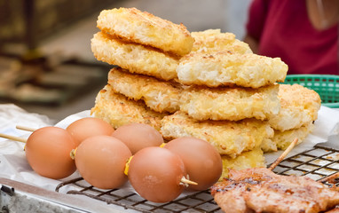 Roast sticky rice lumps (Kgawhie or Khao jee) with Grilled eggs sold on street market, Bangkok, Thailand , Thai traditional recipe 
