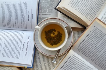 
A cup of green tea rests on books