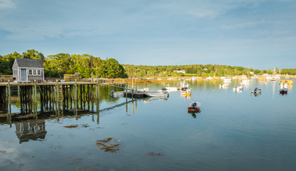 Lobster boats are moored in the harbor at dusk in Friendship, Maine