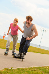 Man encourage woman to do rollerblading