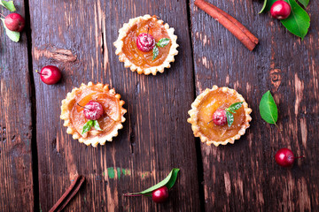 Apple caramel little tarts on brown rustic background. French tatin with paradise apple. Top view.