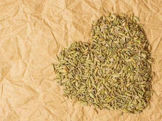 Fennel dill seeds heart shaped on paper surface