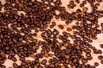 Pile of the roasted coffee beans on wooden table. Top view