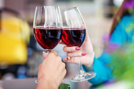 Glasses of red wine in their hands. Toast. The concept of party and celebration.