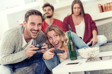 Happy friends using joysticks and having fun