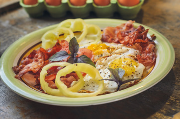 A hearty breakfast of scrambled eggs with bacon and green basil