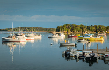 Obraz premium Lobster boats are moored in the harbor at dusk in Friendship, Maine