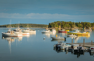 Lobster boats are moored in the harbor at dusk in Friendship, Maine