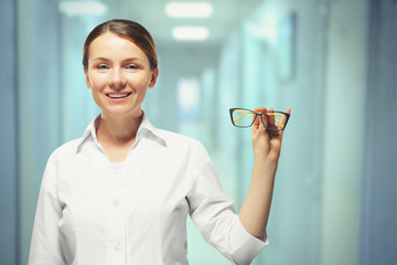 Young woman with spectacles on grey background