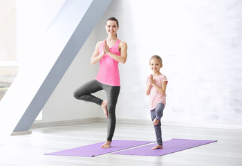 Mother and daughter doing exercise indoors