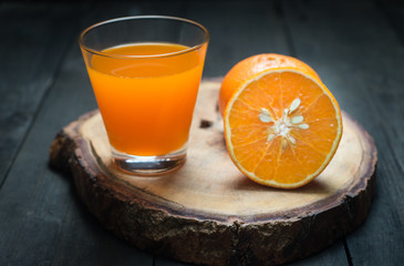 Fresh orange juice in glass on old wooden floor.