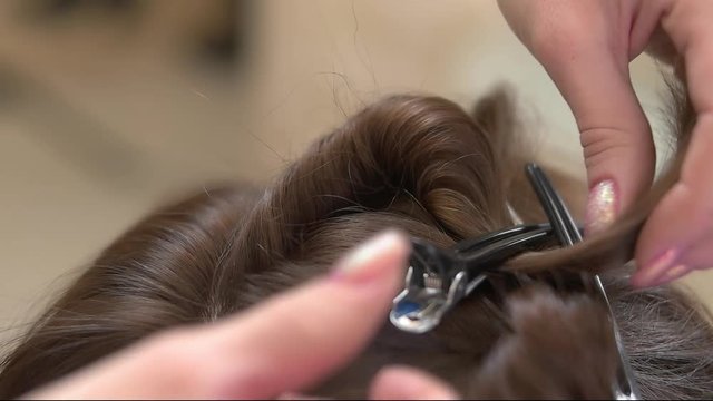 Female hands and hair, barrette. Work of hairdresser close up.