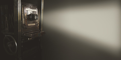 Vintage movie projector with light on gray backdrop use for background or web banner design.