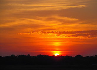 Fototapeta na wymiar The bright evening sun setting over the horizon