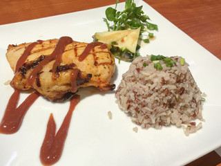 Roasted chicken with sauce served with brown rice and fruit salad