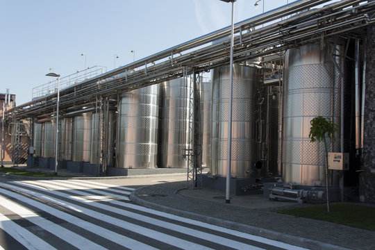 Metal chrome cask for wine photo. Stainless steel pipes and barrels as part of winery equipment