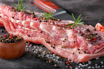Raw ribs with spices on stone background
