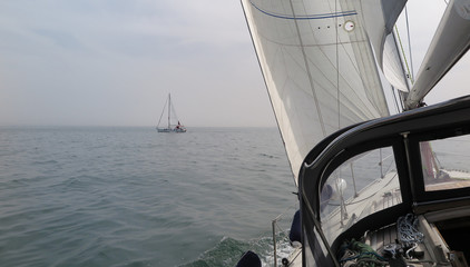 Sail boat gliding in open sea