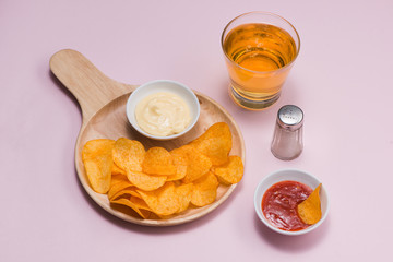 Cheese and onion potato chips with soft drink on pink background.