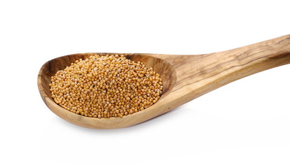 Yellow mustard seeds in wooden spoon isolated on white background