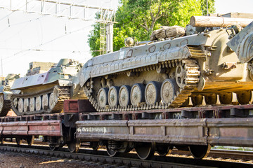 Cargo train carrying military tanks on railway flat wagons