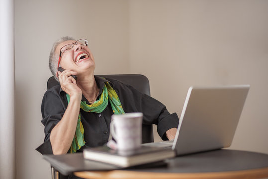 Senior Old Business Woman Having A Pleasant Conversation On Her Phone In Her Office