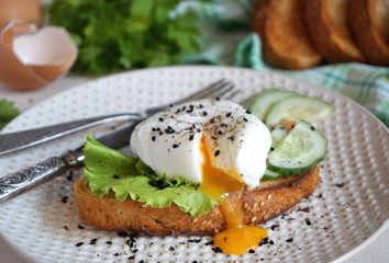 Egg poached on toast with lettuce and cucumber