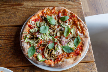 Vegetarian pizza on a white plate in a restaurant