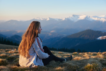 Shot of a young woman sitting on top of a mountain enjoying beautiful view resting after hiking travelling nature tourism concept copyspace