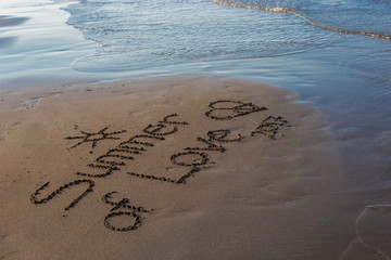 The word summer written on the gray sand on the beach coastline during vacation by the sea in the early morning in summer.