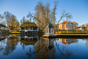Fototapeta na wymiar Manor with a pond, bathhouse and rotunda at sunrise. Palmse, Estonia.