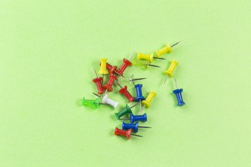 pins on green background. Colorful pushpins