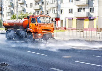 cleaning machine washing the city asphalt road with water spray
