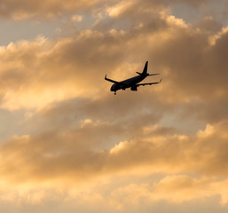 Fototapeta na wymiar The plane is landing at sunset
