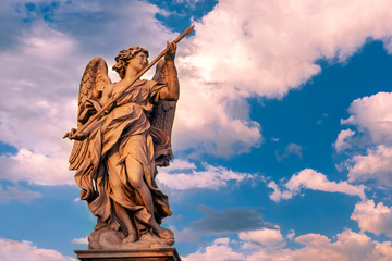 Marble statue of Angel with the Lance at sunset, one of the ten angels on Saint Angel Bridge,...
