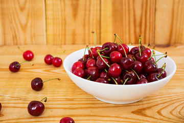 Tasty sweet cherry on wooden background