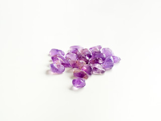 Tumbled Amethyst stones close up on table for crystal therapy treatments and reiki