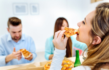 Workers eating pizza in the office