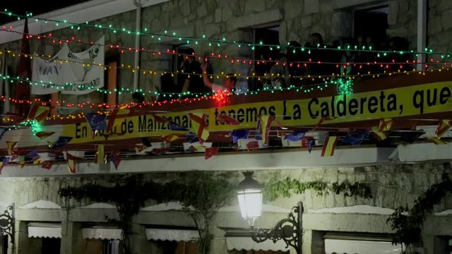 Composition of street lamp, festive banners and balconies of the main square, illuminated at night