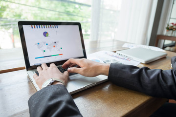 young businessman working on a laptop while sitting at a desk 