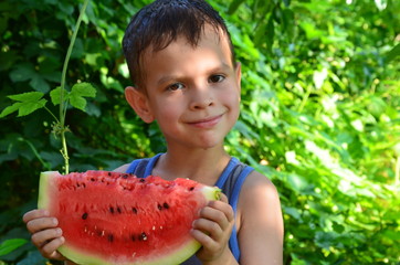happy cute child eating watermelon in the garden